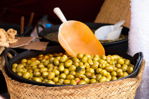 green spanish olives in a basket at street market