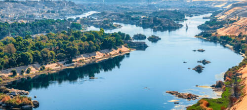 Sunset over the Nile River in the city of Aswan with sandy and deserted shores