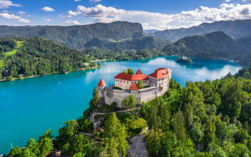 Bled, Slovenia - Aerial panoramic view of beautiful Bled Castle (Blejski Grad) with Lake Bled (Blejsko Jezero), the Church of the Assumption of Maria and Julian Alps at background on a summer day