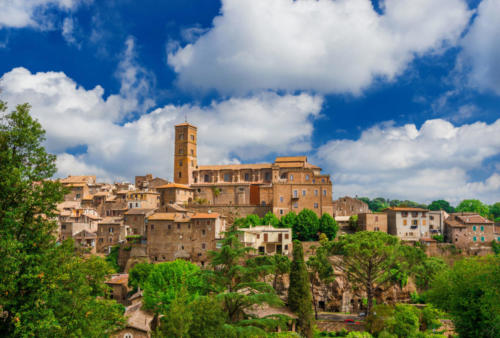 View of the ancient medieval historic center of Sutri among woods and clouds, a small and characteristic ancient town near Rome, along the famous pilgrim route knows as 'Via Francigena'