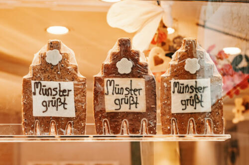 Traditional German festive and souvenir gingerbread on the shop window in Munster. Caption - greeting from Muenster