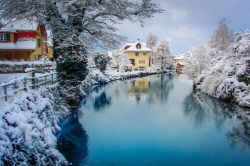 Interlaken landscape after snow in winter with river reflection, Swiss alps